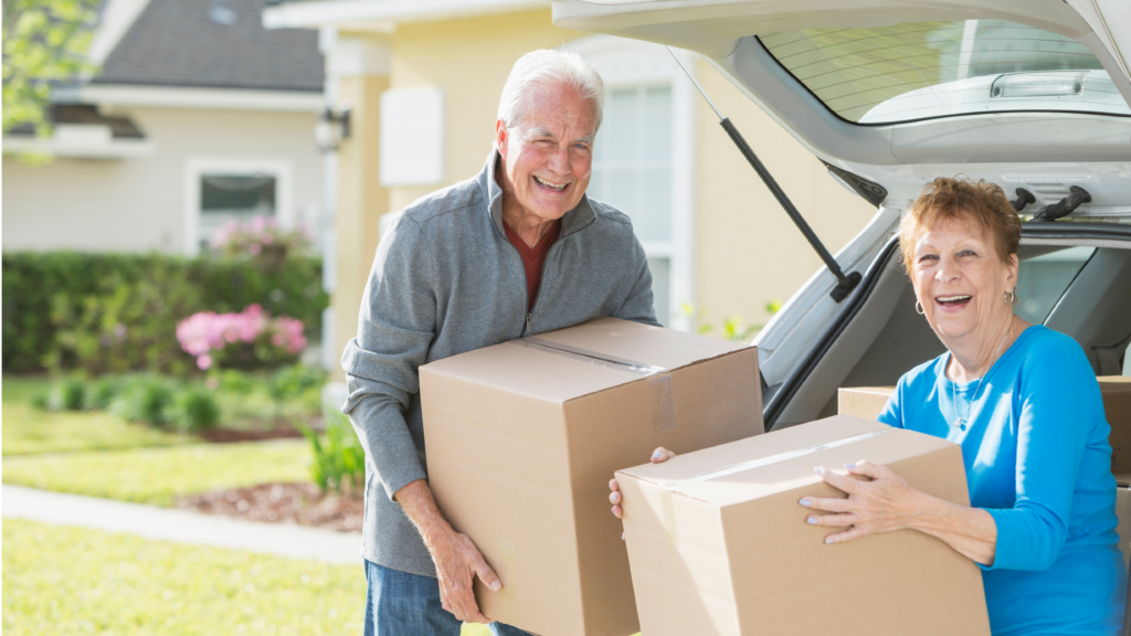 2 Senior citizen carrying box while smiling