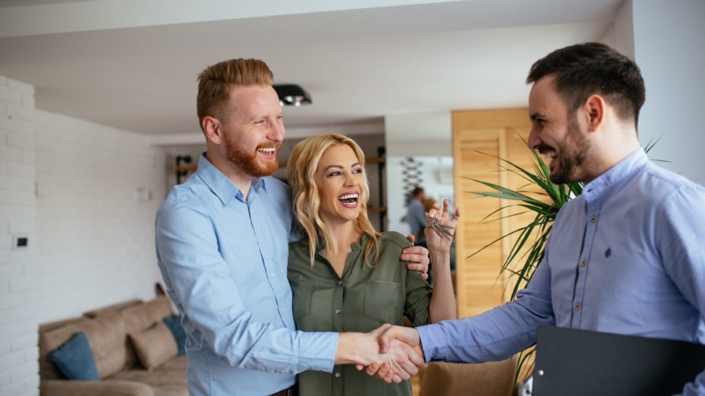 Financial adviser congratulating to a young couple for buying a new house