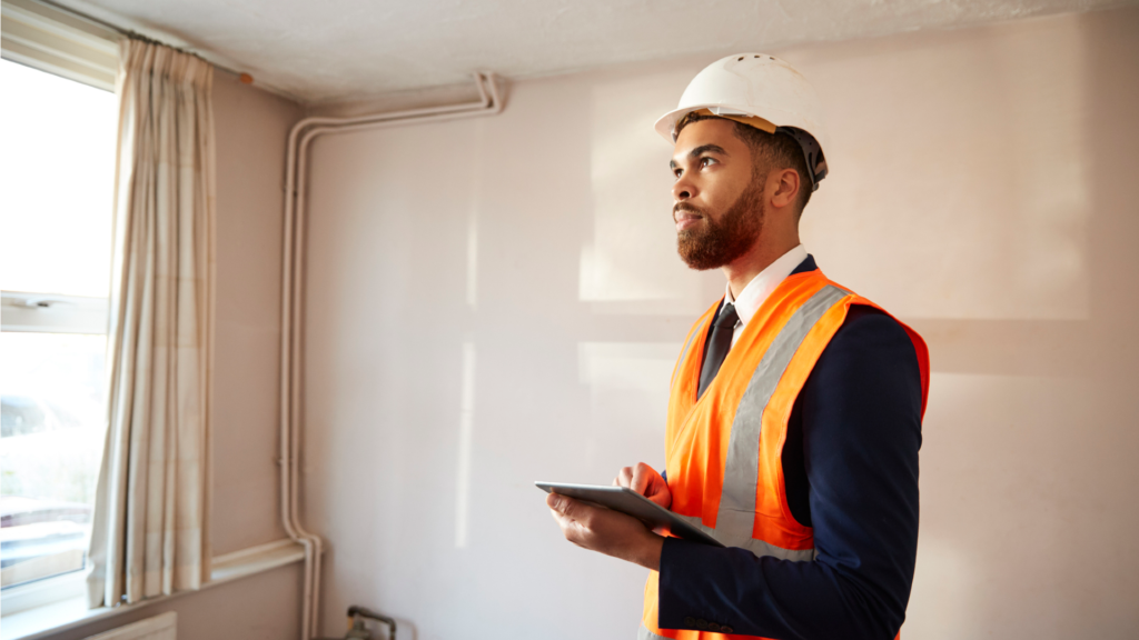 Surveyor With Digital Tablet Carrying Out House Inspection